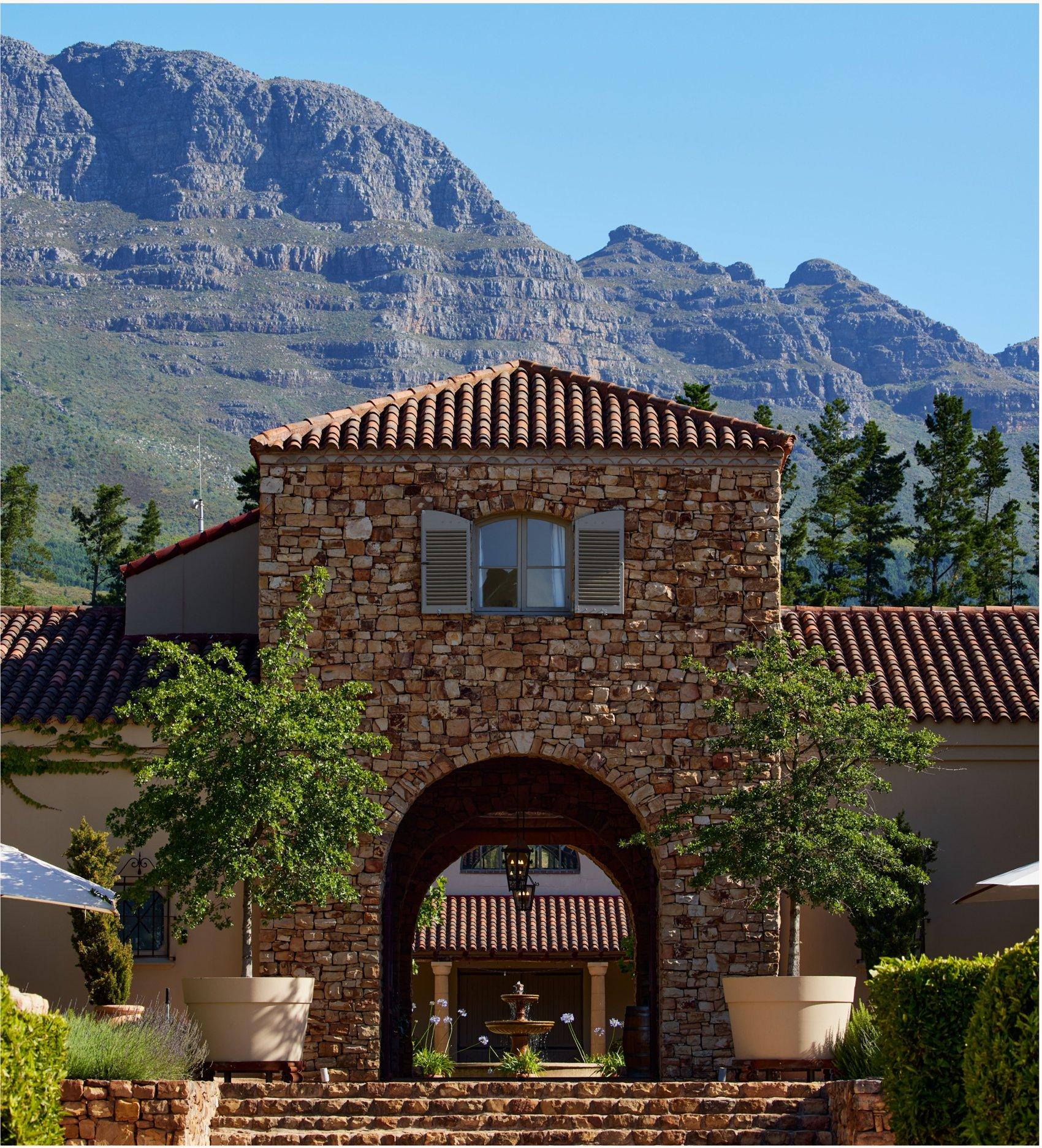 A stone lodge set beneath a mountain range